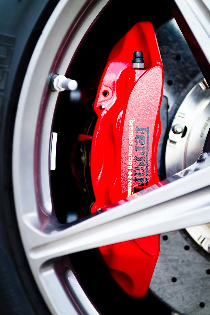 4 piston brakes on a high-performance car with a red fixed caliper behind the wheel