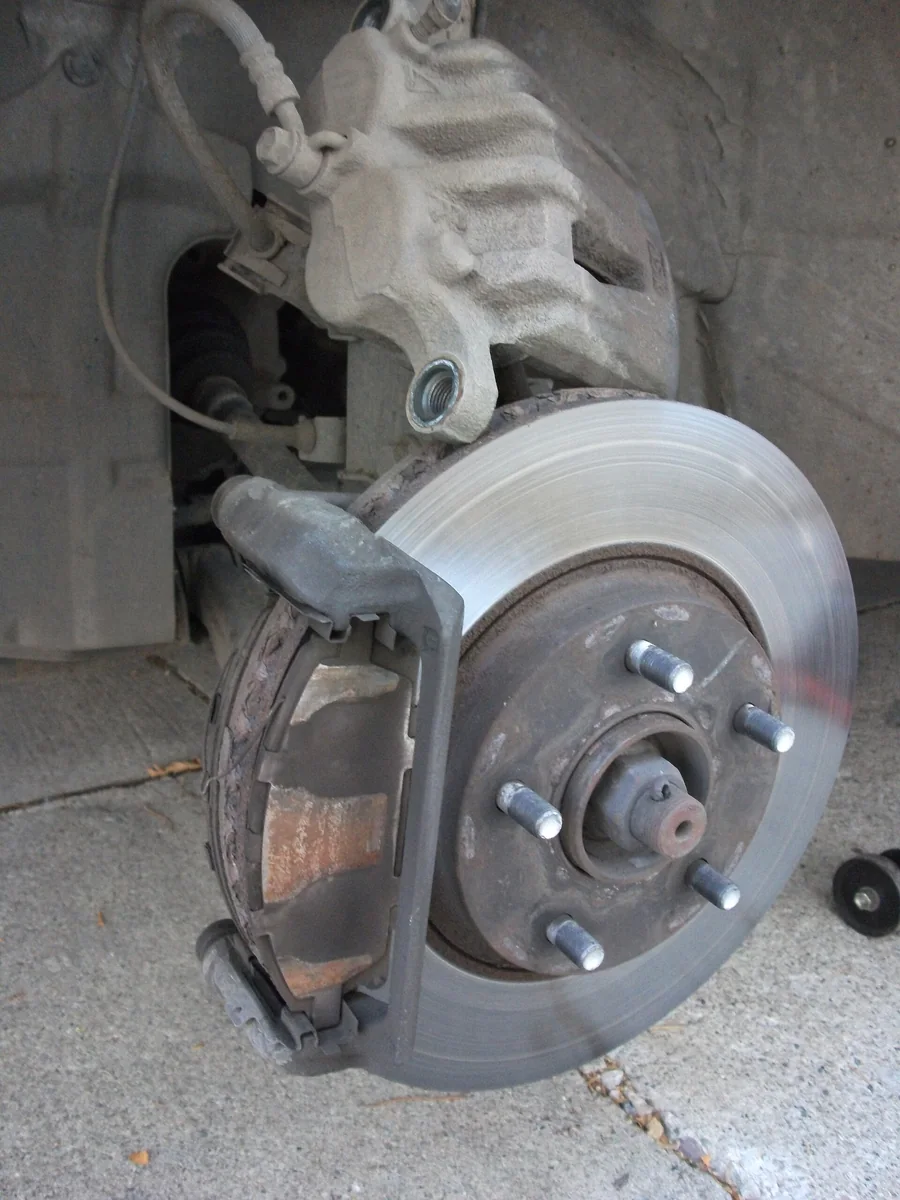 single-piston floating brake caliper and disc rotor on a regular passenger car