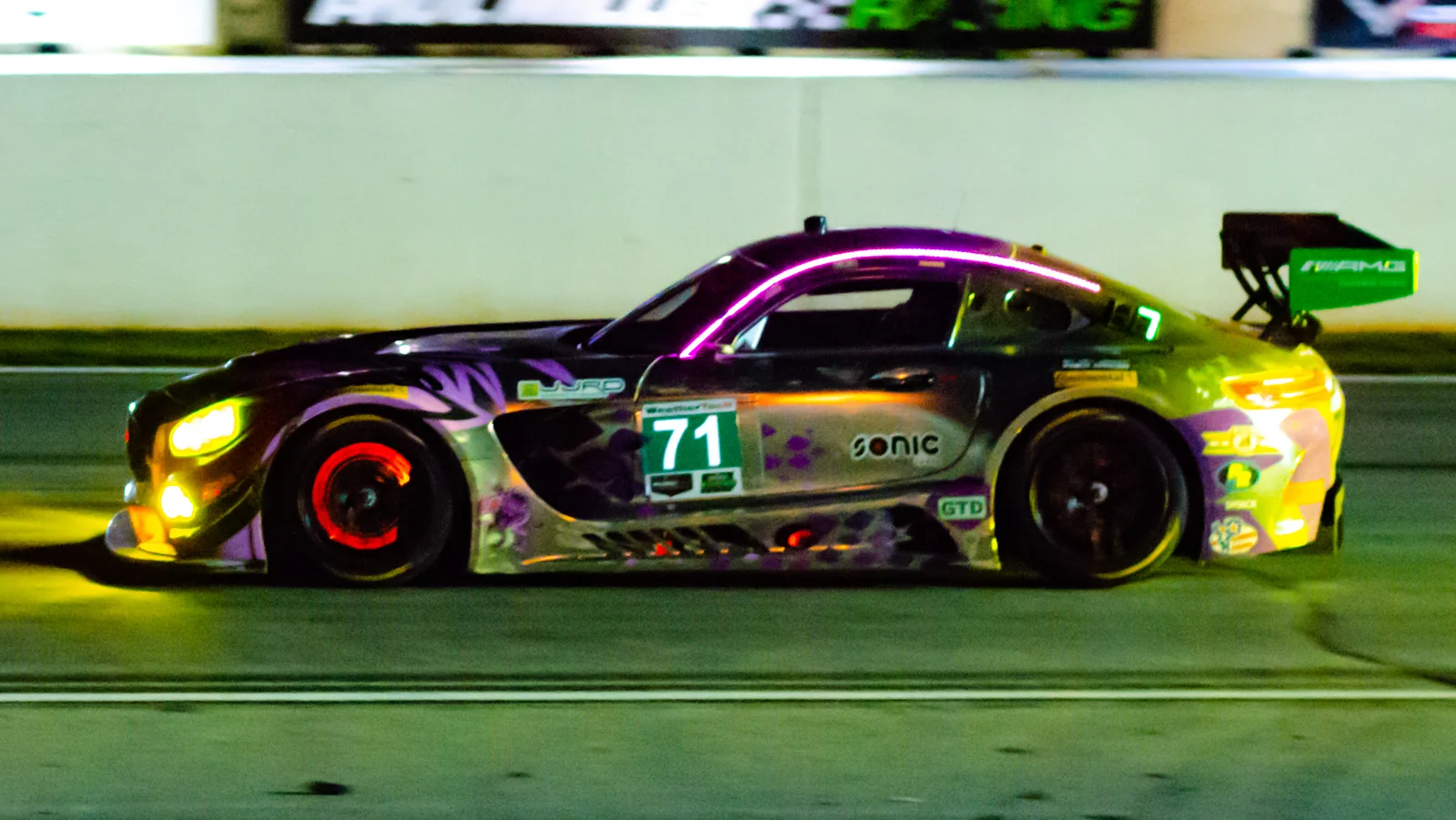 race car at night with a glowing brake disc after repeated high-speed braking