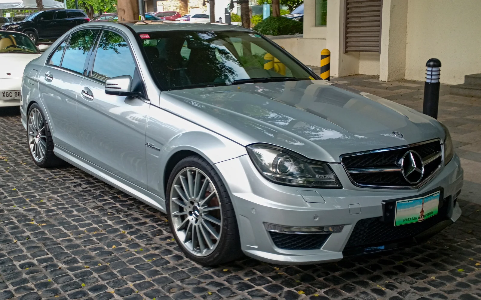 silver Mercedes-Benz W204 C63 AMG sedan seen from the front right