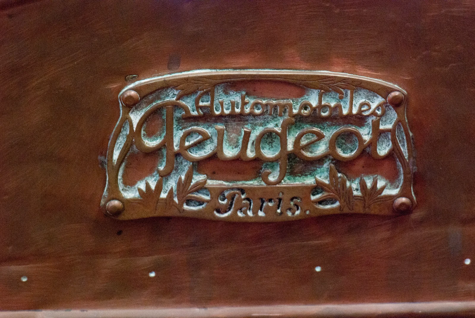 historic Peugeot lion emblem mounted on a wooden surface