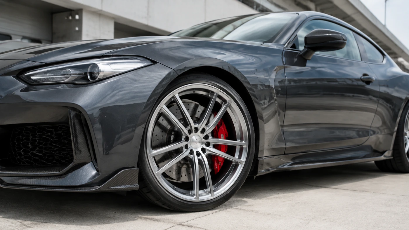 Bigger Brakes illustration showing a gray coupe with a large brake disc and red caliper visible through its front wheel