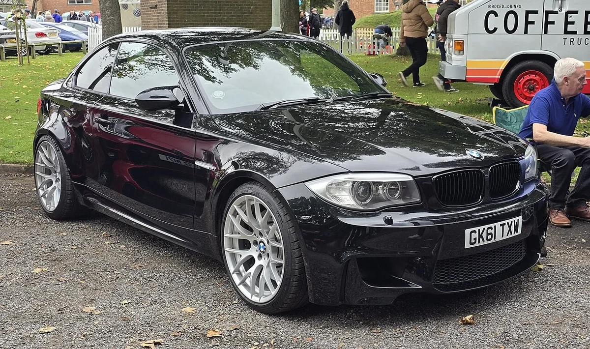 Black BMW 1M at an outdoor car gathering