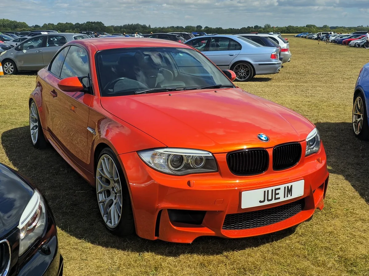 Orange 2011 BMW 1 Series M at a gathering