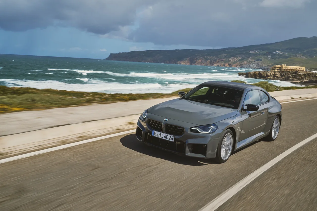 Grey BMW M2 G87 driving on a coastal road