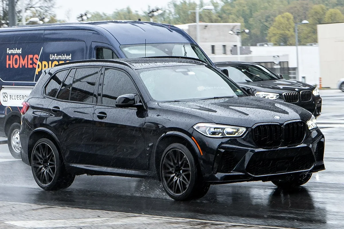 Black BMW X5 M F95 on an urban street