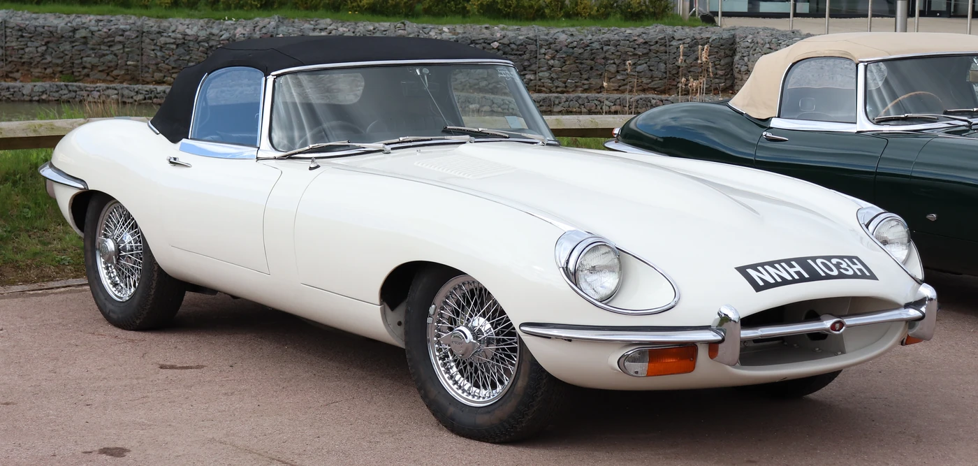 White 1970 Jaguar E-Type roadster showing curved hood and rounded wheel arches
