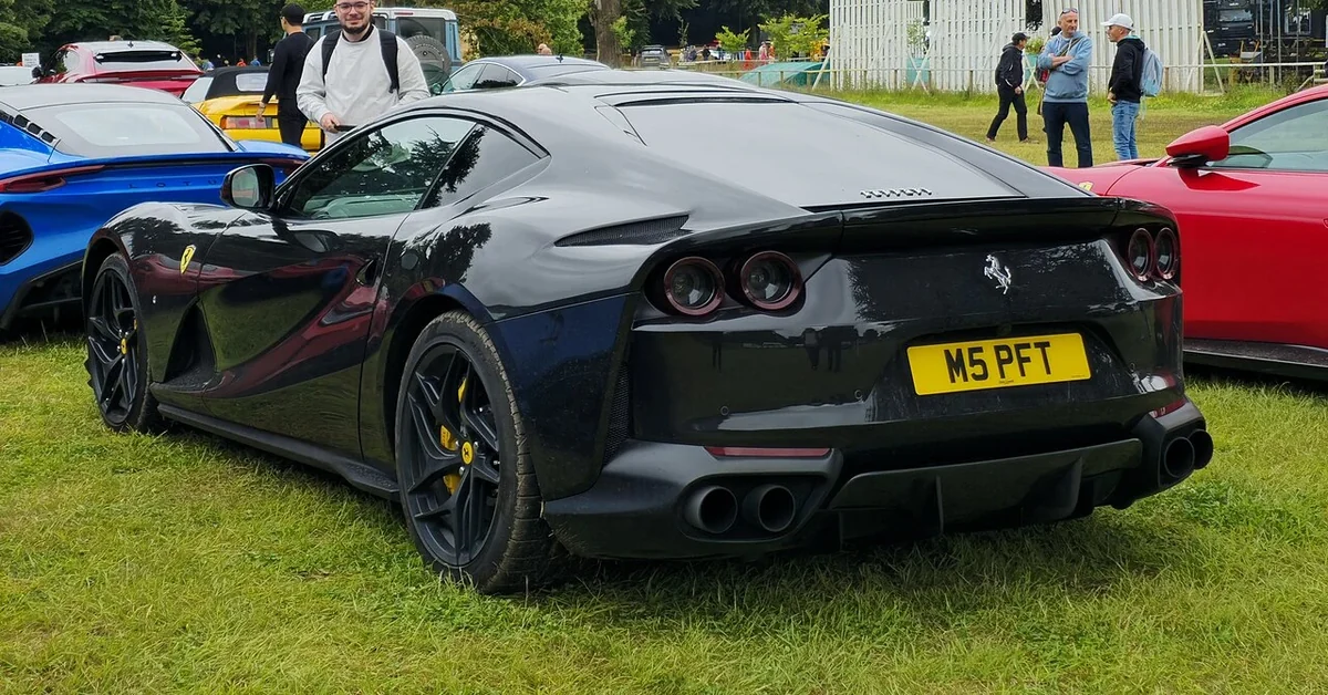 Black Ferrari 812 Superfast coupe rear at an outdoor gathering