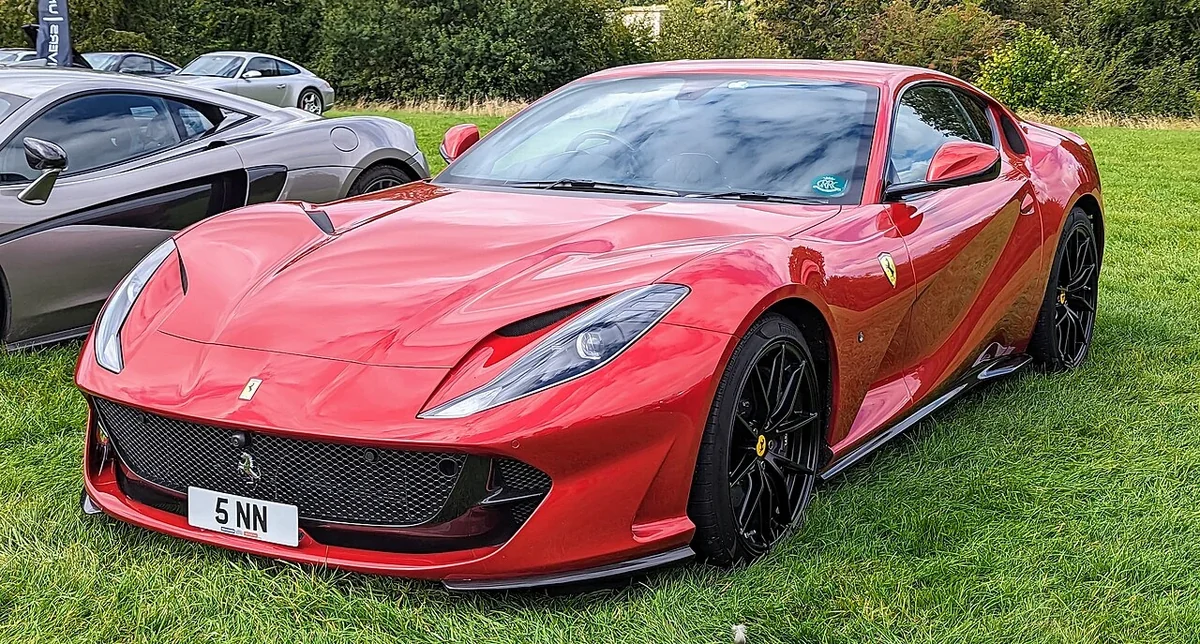 Red Ferrari 812 Superfast coupe at an outdoor event