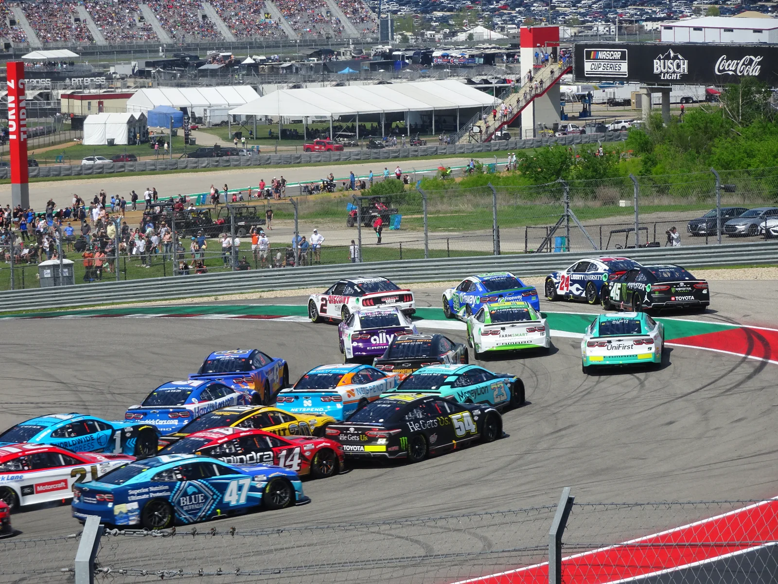 NASCAR stock cars packed together through turn one at Circuit of the Americas