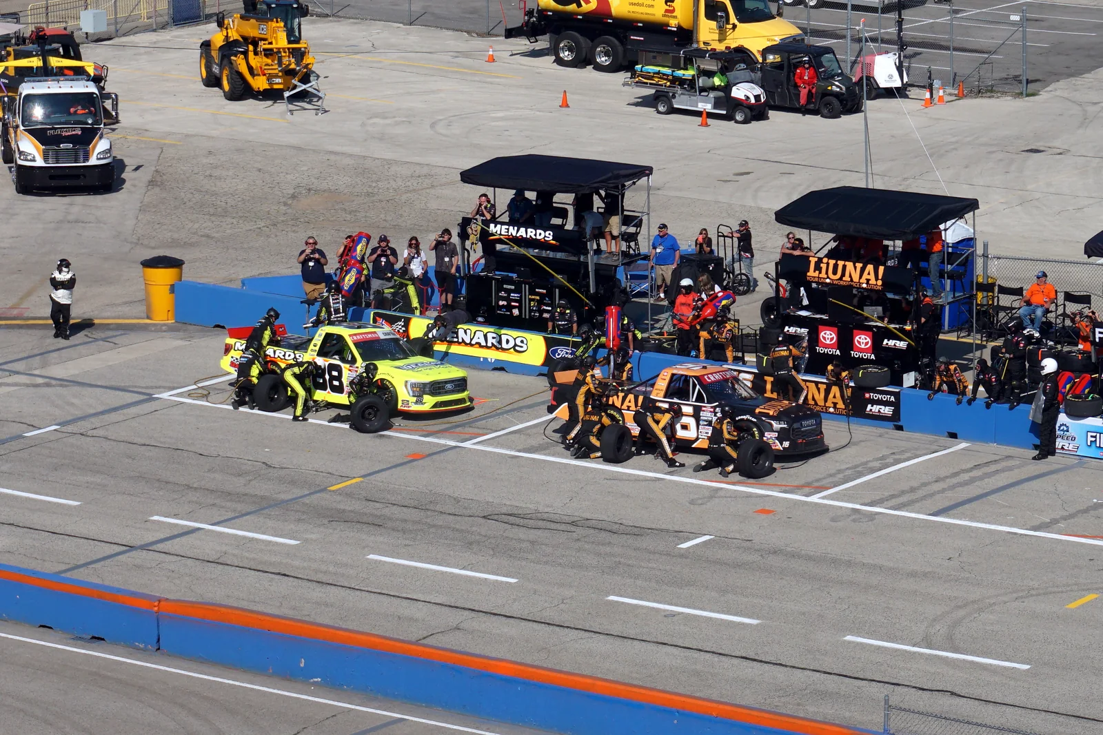 NASCAR pit lane filled with teams and race cars during an event