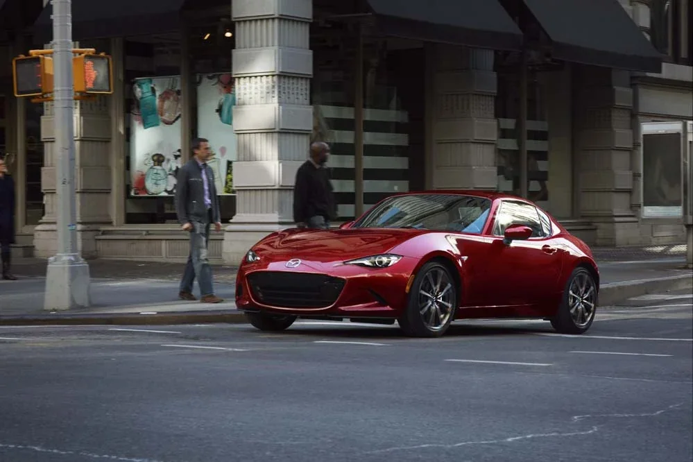 Red Mazda MX-5 Miata RF parked on a city street