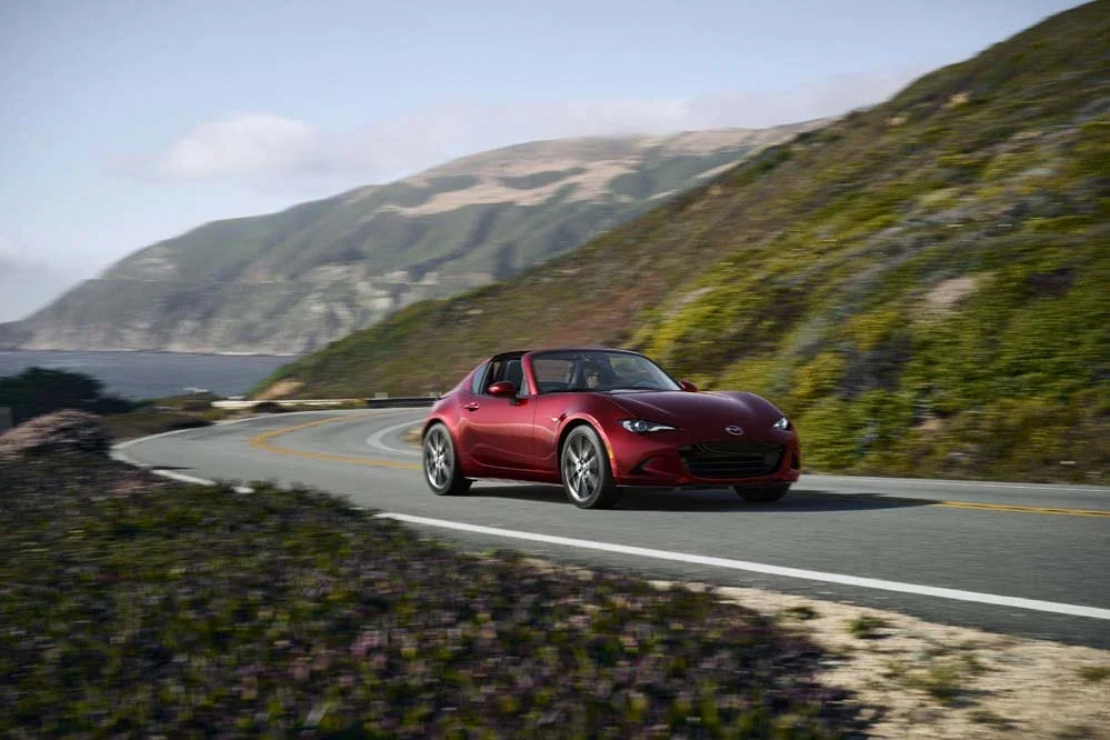 Red Mazda MX-5 Miata RF on a coastal road