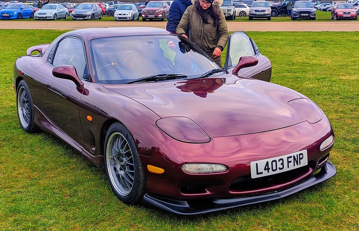 Red Mazda RX-7 FD with nonstandard wheels at a car gathering
