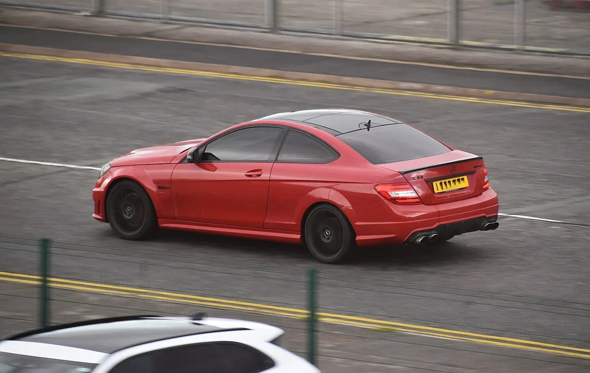 Red Mercedes C63 AMG C204 coupe on an urban road