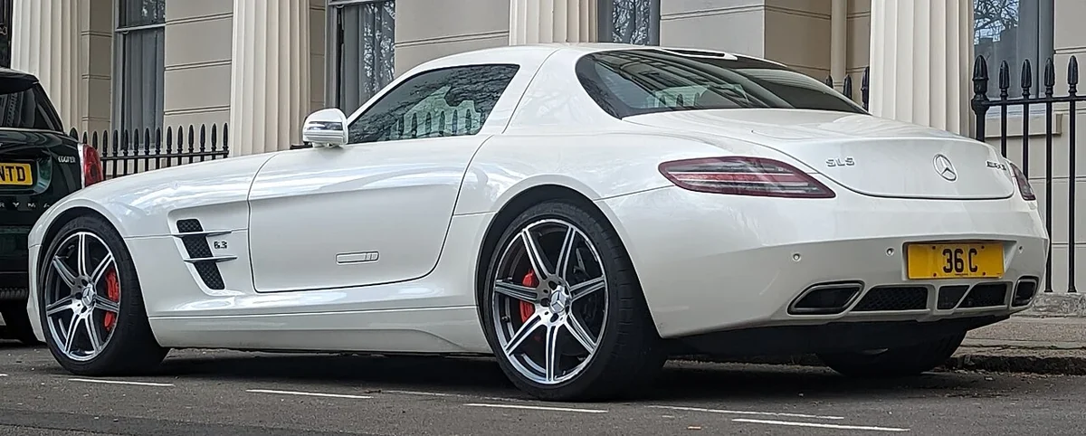 Original SLS AMG coupe in white, illustrating its distinctive touring proportions.