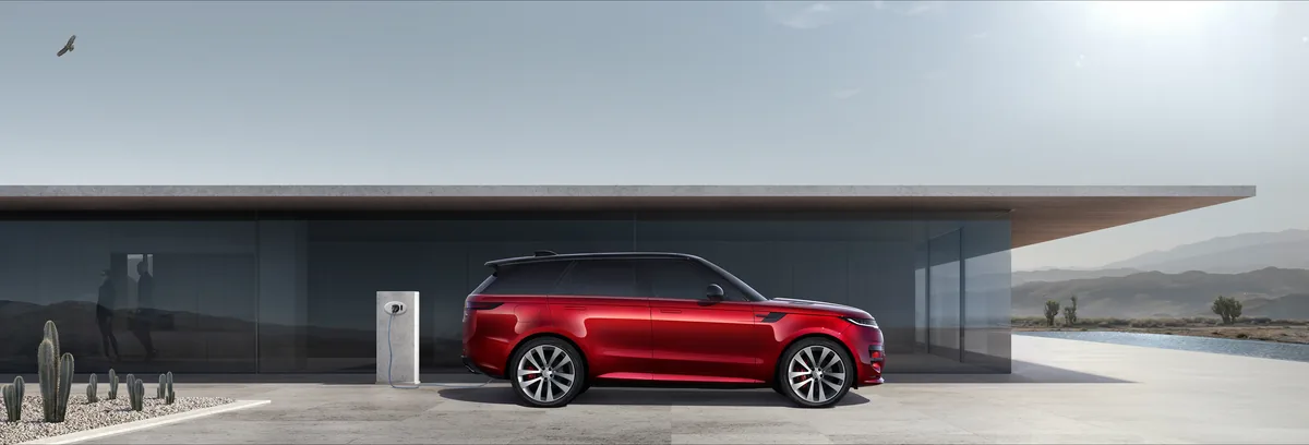 Range Rover Sport plug-in hybrid charging beside a modern home