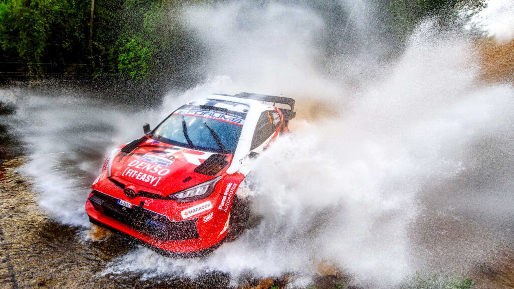 Rally car rotating through water and spray during a WRC stage