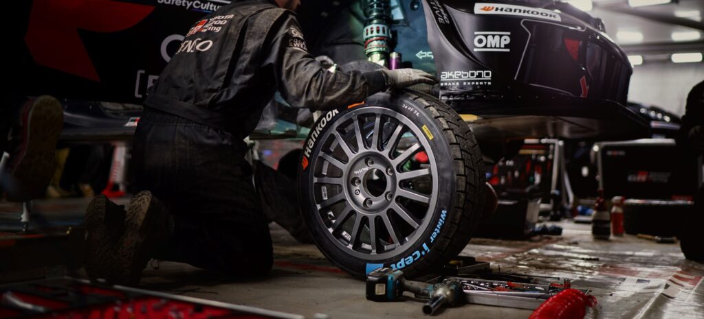 WRC service park mechanic changing a rally tire