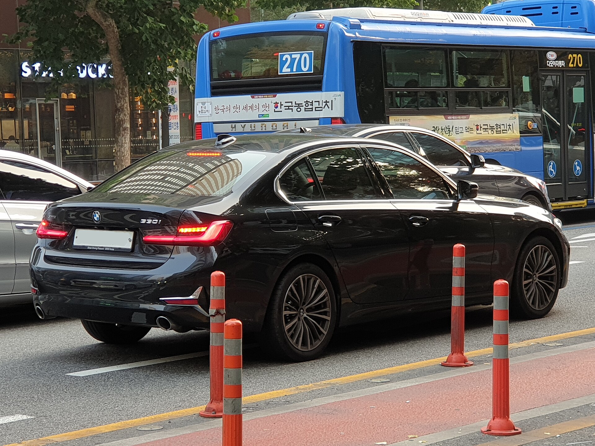 BMW 330i G20 black G20 Luxury Line rear-left three-quarter view on a street