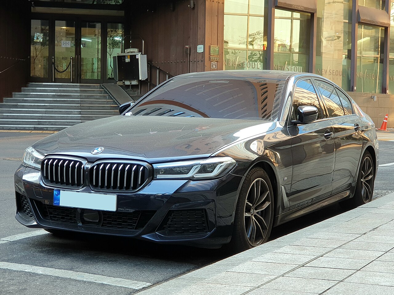 BMW 520i black facelift M Sport alternate front three-quarter view