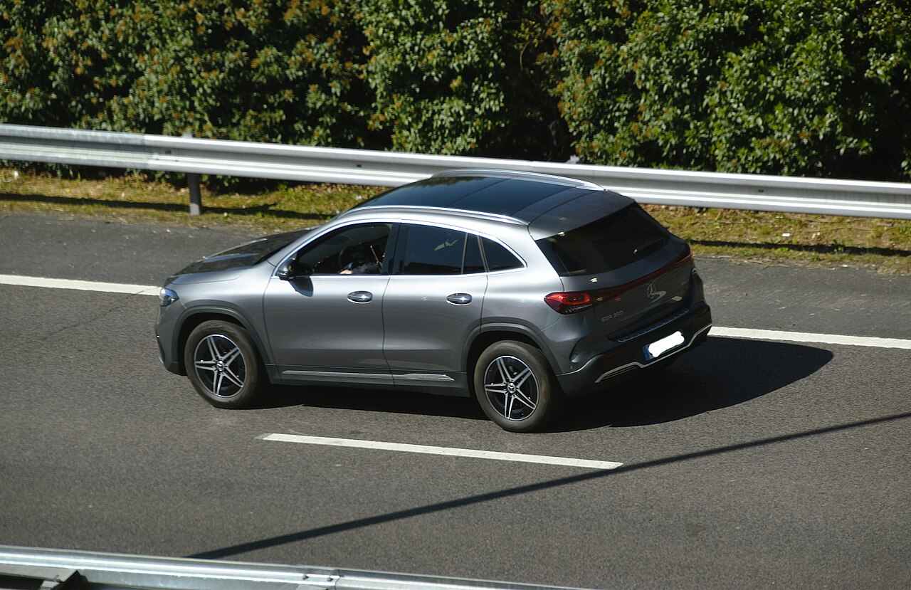 Mercedes-Benz EQA 350 4MATIC grey 2022 pre-facelift rear-side view on a road