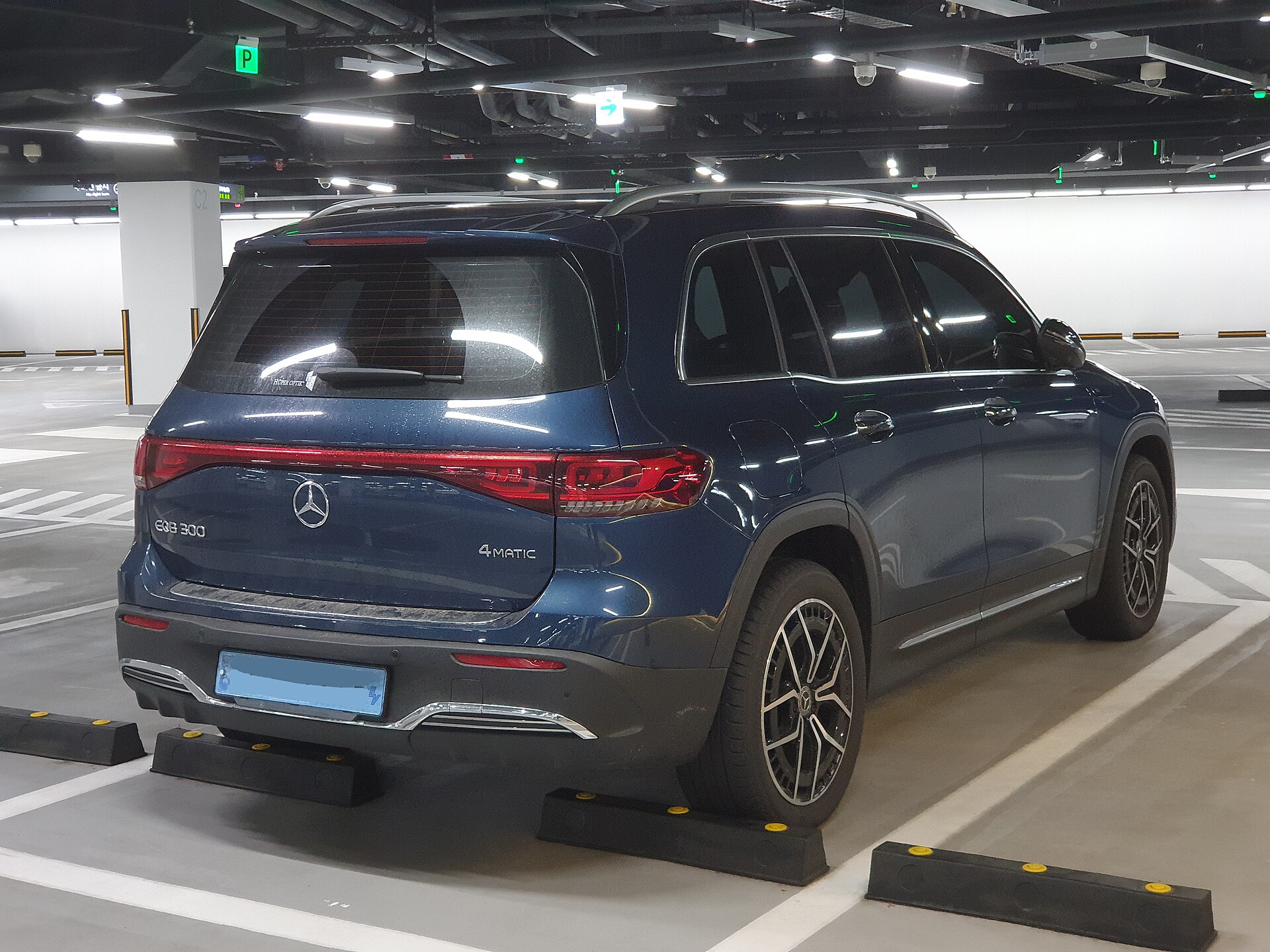 Mercedes-Benz EQB 300 4MATIC X243 blue AMG Line rear three-quarter view with EQB 300 4MATIC badging