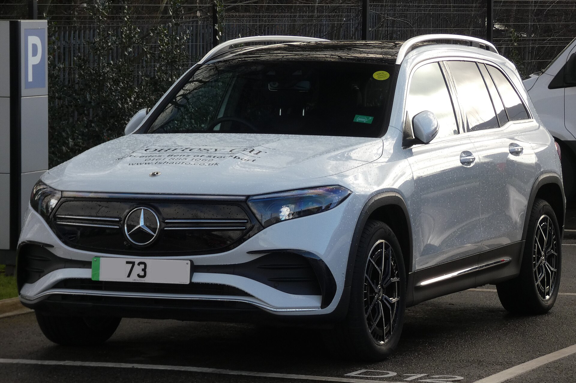 Mercedes-Benz EQB 300 4MATIC X243 white AMG Line front three-quarter view with a dealership hood graphic