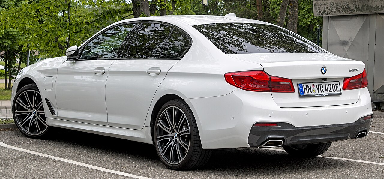 White early G30 BMW 530e rear three-quarter view