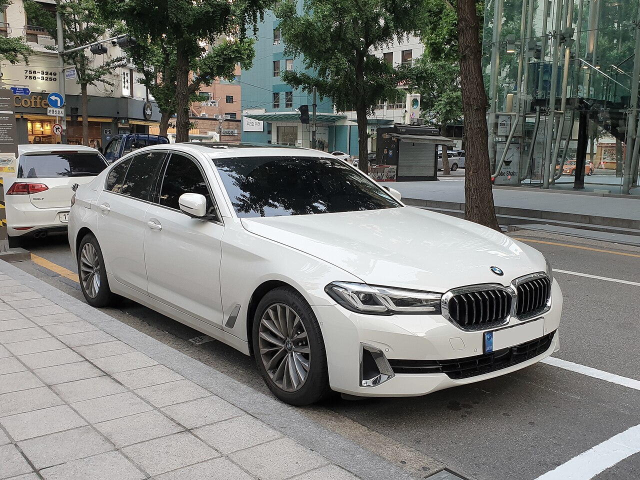 White early G30 BMW 530i front three-quarter view