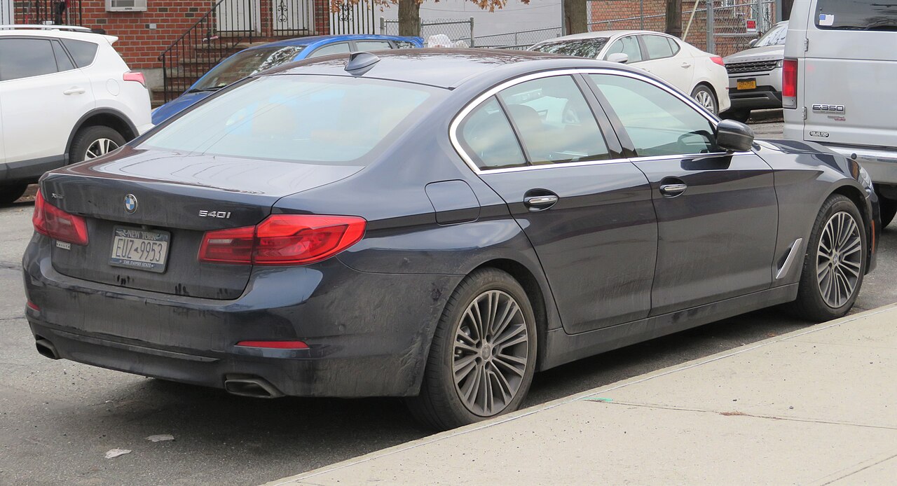 Blue-grey BMW 540i xDrive rear three-quarter view