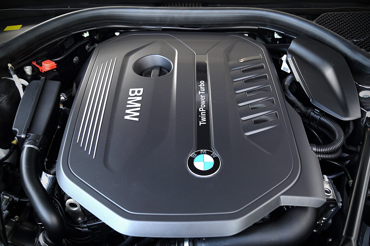 Covered inline-six engine bay of early BMW 740i