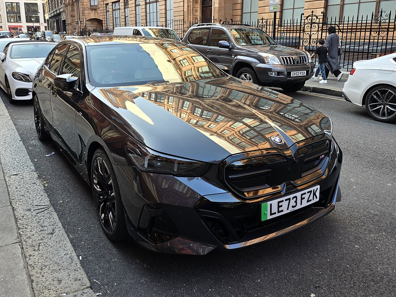 Dark 2024 BMW i5 M60 xDrive G60 sedan parked on a street