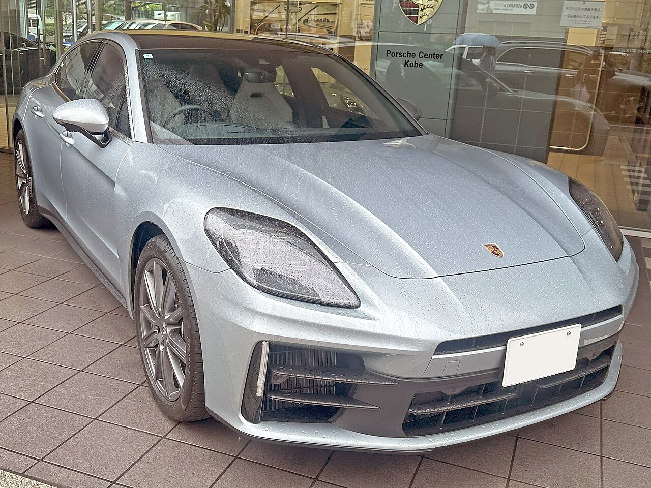 Silver Porsche Panamera 4 behind showroom glass