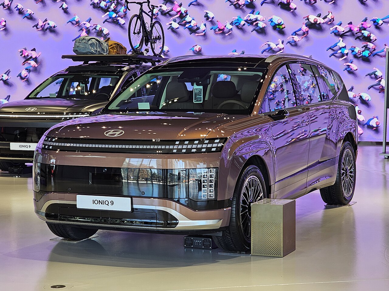 Bronze Hyundai IONIQ 9, front three-quarter view at a showroom