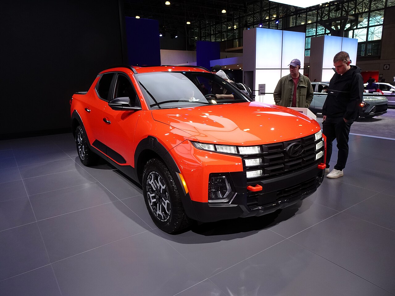Orange Hyundai Santa Cruz XRT, front three-quarter view at an auto show