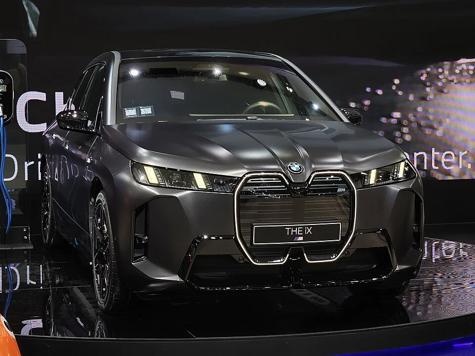 Front exterior — BMW iX M70 at the 2025 Seoul show; exterior and rear lamp/badge detail, with market-specific equipment.