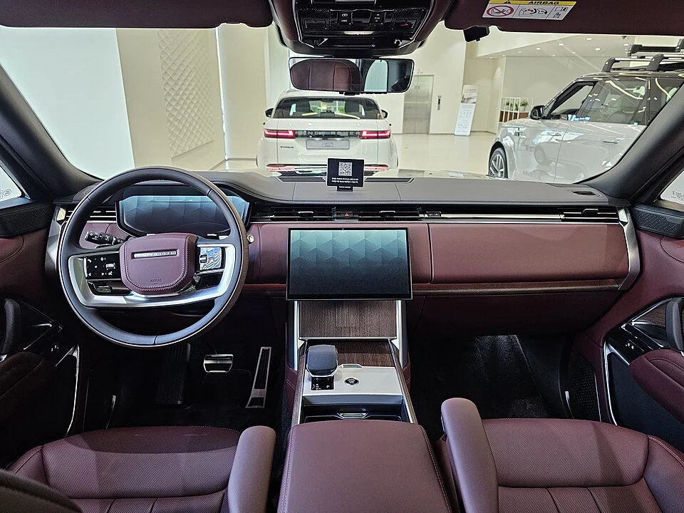 Interior — Range Rover L460 exterior and a separate dashboard example photographed overseas; upholstery and seating are configuration-specific.