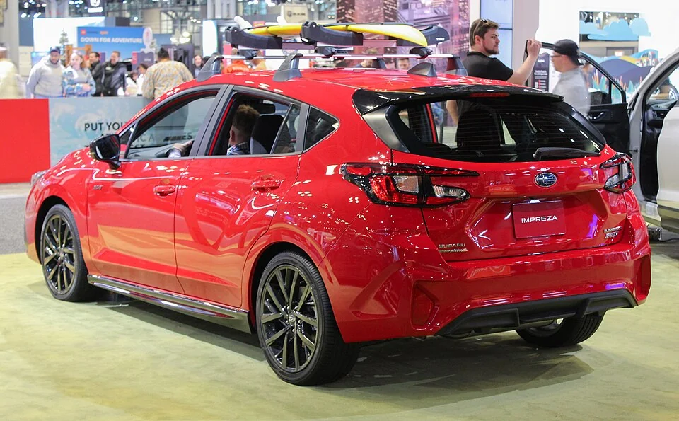 Rear exterior — 2024 Subaru Impreza displayed at the 2023 New York auto show; the roof carrier is display equipment, not a standard feature on every trim.